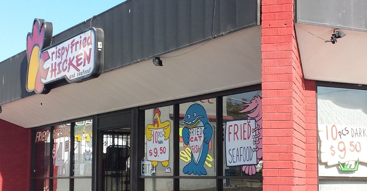Crispy Fried Chicken storefront on El Cajon Blvd, with its hand-painted windows advertising fried chicken, catfish, and seafood